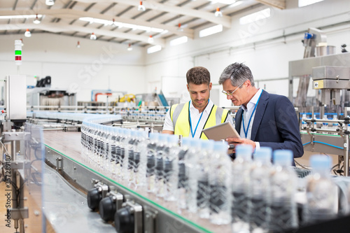 Cuadros en Lienzo Supervisor and manager watching plastic bottles on conveyor belt