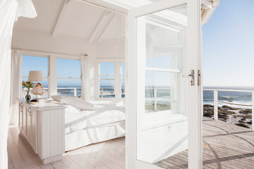 White bedroom overlooking ocean