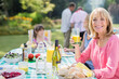 © Paul Bradbury/KOTO - Smiling woman enjoying lunch at table in backyard