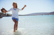 © Paul Bradbury/KOTO - Young girl splashing in water on beach