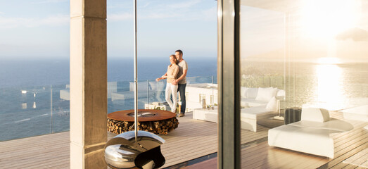 Couple on modern balcony overlooking ocean