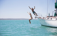 Couple Jumping Off Boat Into Water 