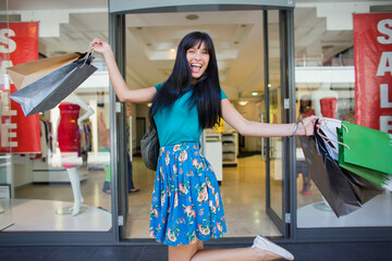 Poster - Woman carrying shopping bags outside clothing store