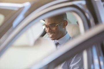 Smiling businessman sitting in car