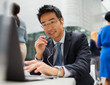 © Dan Dalton/KOTO - Businessman sitting at table talking on headset