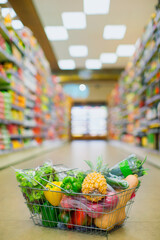 Close up of full shopping basket on floor of grocery store