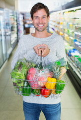 Sticker - Man holding full shopping basket in grocery store