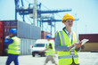 Businesswoman using digital tablet near cargo containers