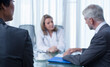 © Dan Dalton/KOTO - Female doctor, man and woman talking at table in conference room