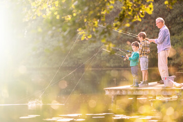 Wall Mural - Grandfather and grandsons fishing at lake