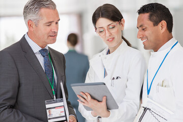 Scientists and businessman reading digital tablet