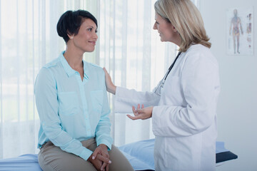 Wall Mural - Smiling female doctor talking to patient in office