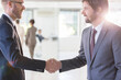 © Sam Edwards/KOTO - Businessmen wearing suits shaking hands in office, colleagues