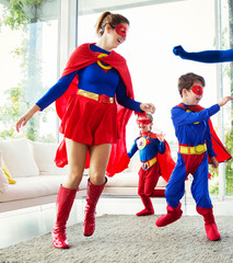 Family of superheroes playing in living room