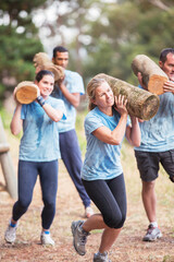 Wall Mural - Determined people running with logs on boot camp obstacle course