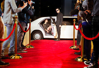 bodyguard opening limousine for celebrity arriving at red carpet event