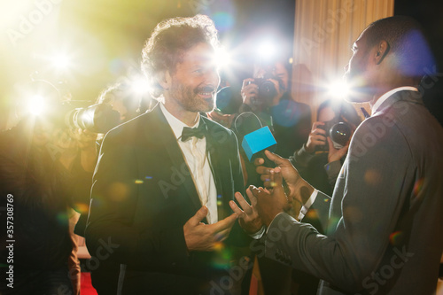 Fotomural Celebrity being interviewed and photographed by paparazzi at event