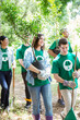 © Robert Daly/KOTO - Smiling environmentalist volunteers planting new tree