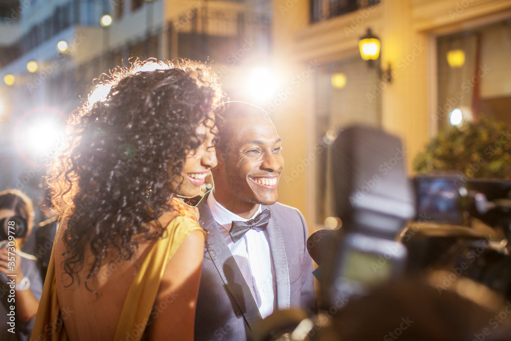 Smiling celebrity couple being interviewed photographed by paparazzi at ...