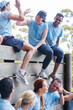 © Sam Edwards/KOTO - Team celebrating at wall on boot camp obstacle course