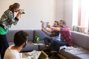 Wall Mural - Creative businessmen proofs posing for coworker instant camera