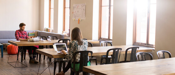 Wall Mural - Casual business people working at tables in open office