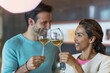 © Tom Merton/KOTO - Smiling couple toasting white wine glasses