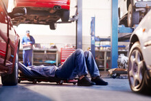Mechanic Under Car In Auto Repair Shop