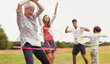 © Paul Bradbury/KOTO - Playful multi-generation family spinning in plastic hoops in field