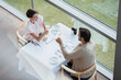 © Tom Merton/KOTO - Couple toasting wine glasses at restaurant table at window