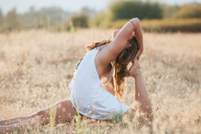 Boho Woman In Royal King Pigeon Pose In Sunny Rural Field