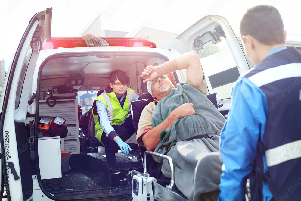Rescue workers loading car accident victim into back of ambulance Stock ...