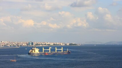 Wall Mural - Large bulk carrier ship with deck cranes sailing in to Marmara Sea. Cargo ship sailing out with a pilot on board. Zoom in, HD video.
