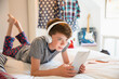© Chris Ryan/KOTO - Boy with headphones listening to music on digital tablet