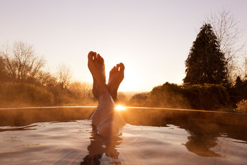 Man‚Äôs feet raised out of pool