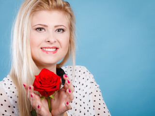 Woman holding red rose flower on blue