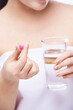 © elenavolf - Girl holding a pill. Vitamins concept. Beautiful portrait on white background. Medicine home routine. Female morning supplement. Meds anti allergy drug. Vertical