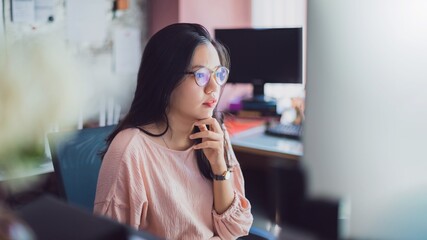 Asian young business woman working from home office.New normal lifestyle concept of lockdown, quarantine and social distancing to stop the spread disease of Coronavirus.Remote work online technology.