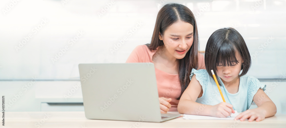 Mother teaching children to do their homework at home. Happy asian ...