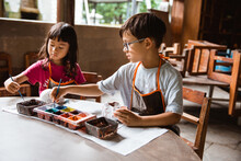 Children Coloring Clay Handicrafts With Brushes And Paint In The Pottery Workshop Gallery