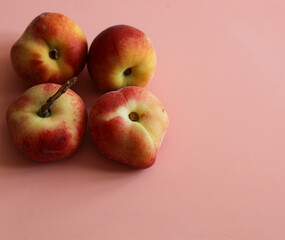 ripe juicy peaches on a pink background close up