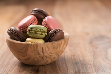 Wall Mural - Various french macarons in olive wood bowl with copy space