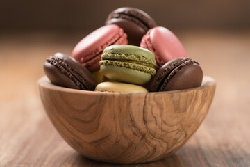 Wall Mural - Various french macarons in olive wood bowl closeup