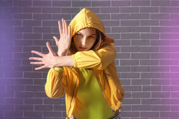 Wall Mural - Beautiful female hip-hop dancer against brick wall