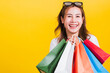 © sorapop - Asian Thai portrait happy beautiful cute young woman smiling stand with sunglasses excited holding shopping bags multi color looking camera, studio shot isolated yellow background with copy space