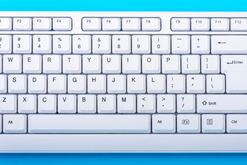 Poster - Keyboard isolated. White keyboard on blue background. Top view. Close up
