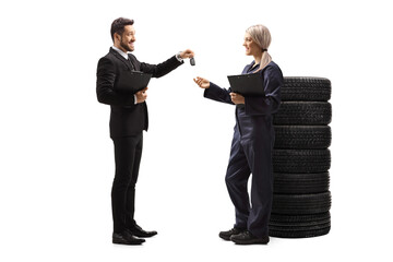 Canvas Print - Businessman handing car keys to a female auto mechanic