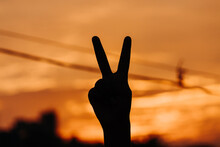 Silhouette Of Hand Showing Peace Sign During The Sunset