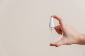 Light-skinned Asian woman holding a hand sanitizer spray bottle. Shows hygiene and cleanliness for virus or bacterial spread prevention