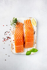 Wall Mural - Raw salmon fillet and ingredients for cooking, seasonings and herbs on a white background . Top view